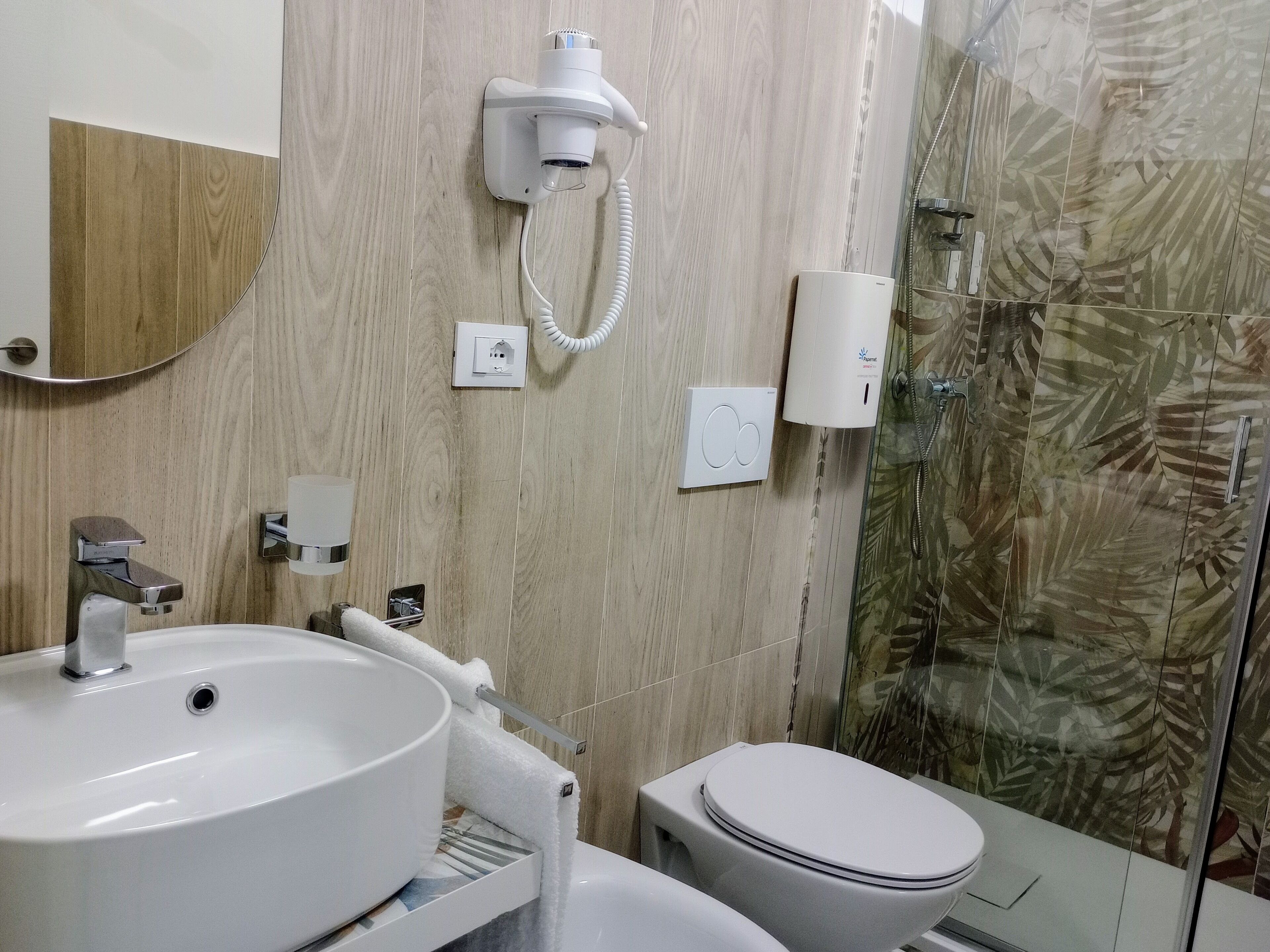 Un baño con lavamanos, inodoro y ducha.