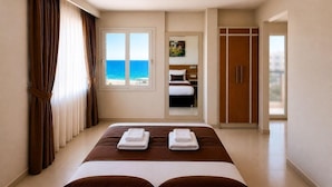 A hotel room with a bed, a wardrobe, a bathroom, and a view of the ocean. - PALM BEACH HOTEL (Silifke)