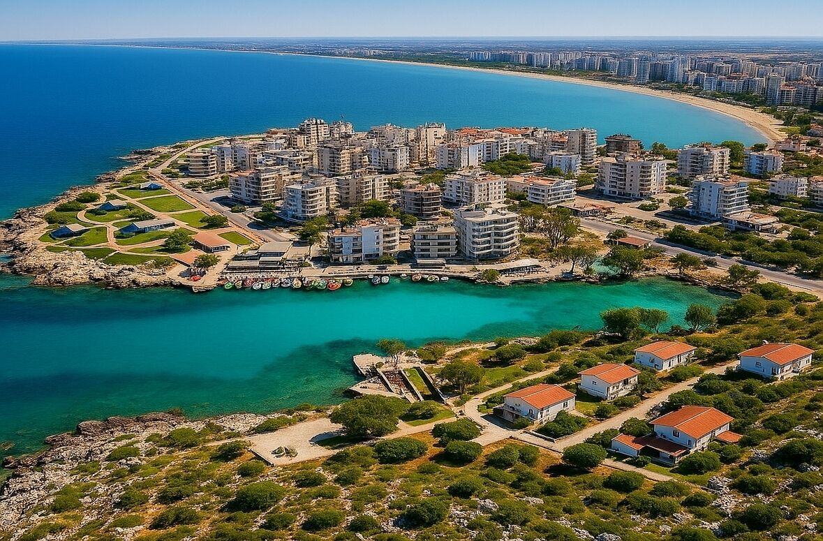 Vue aérienne d’une zone résidentielle côtière, avec des immeubles d’appartements, un port de plaisance et une plage.
