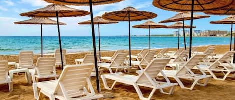 Nära stranden, solstolar och parasoller