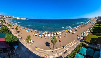 Una playa cerca, sillas reclinables de playa, sombrillas