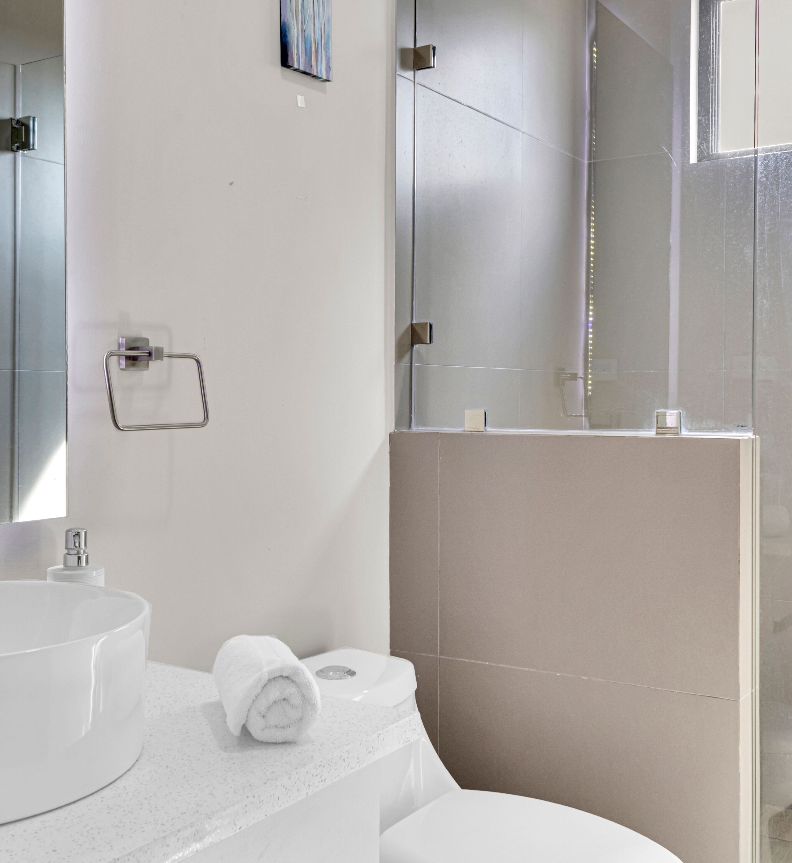 Une salle de bain moderne avec un grand lavabo rond, des toilettes et un espace douche.