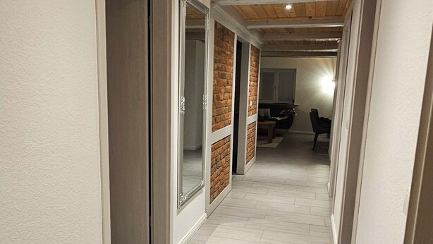 A hallway with wooden ceiling, white walls, and light-colored flooring. - Simones-Ferienhaus.de Cozy vacation in North Friesland for up to 6 people. (Drage)
