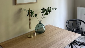 A framed floral artwork titled "Flower Market" with a vase of green leaves on a wooden table. - Beautiful apartment in a quiet location with good connections to Potsdam and Berlin (Potsdam)
