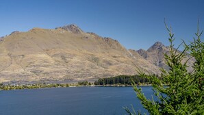 Un paisaje montañoso con un lago y un pequeño asentamiento en primer plano.