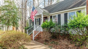 A house with a porch, a staircase, and an American flag. - RVA Old Willow Bungalow | Quaint & Quiet | 2 Kings (Richmond)