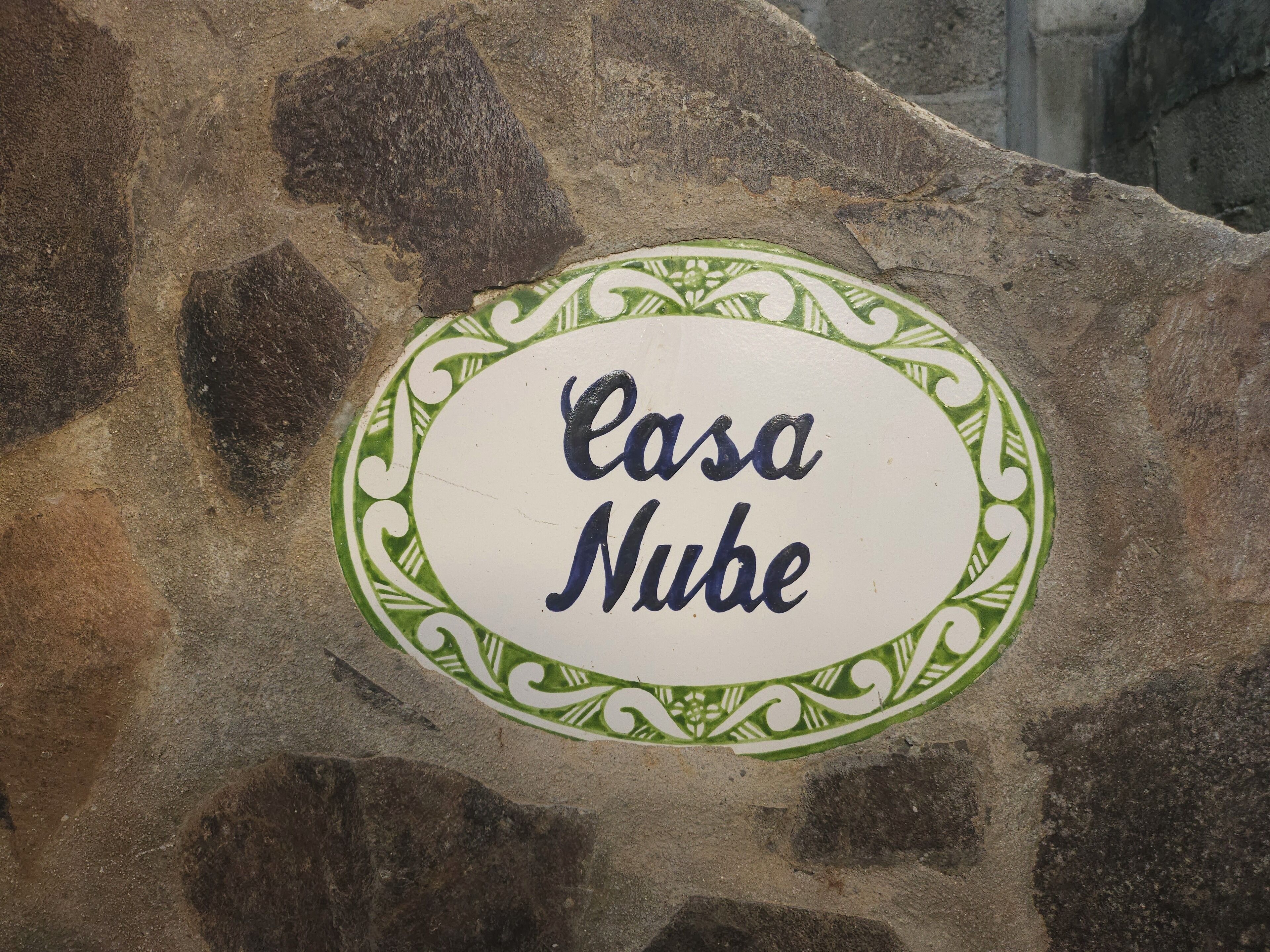 Una placa de piedra con la inscripción 'Casa Nube' rodeada por una moldura decorativa.