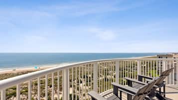 Ein Balkon mit Blick auf den Strand und den Ozean.