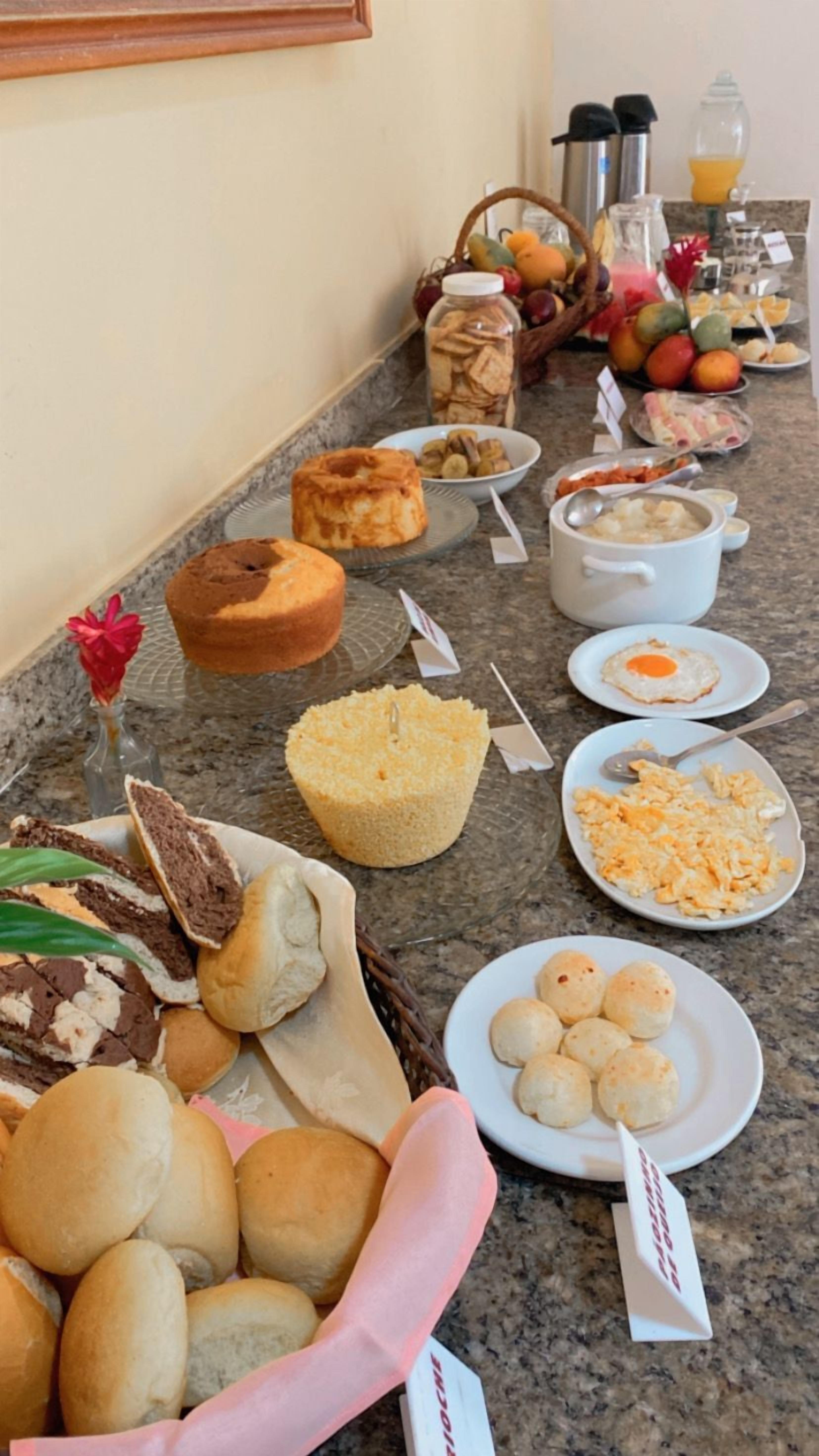 Una mesa de buffet con diversas opciones de comida, como pan, pasteles y frutas.
