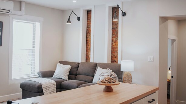 A modern living room with a grey sofa, a wooden coffee table, and a lamp. - Charming 2-bedroom apartment with AC, WiFi in lovely Mifflinburg (Mifflinburg)