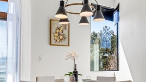 A dining area with a round table, four chairs, a chandelier, and a window with a view. - Quiet getaway w/2 kings, 3 beds pet friendly (Flagstaff)