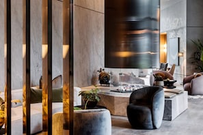 Relax in a cozy seating area with a fireplace, large mirror, and natural touches.