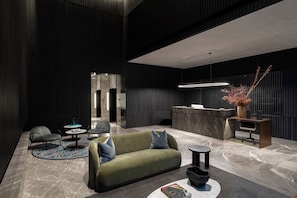 Relax in the elegant lobby, featuring a reception desk, comfortable seating, and a warm atmosphere.