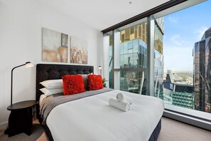 Relax in a stylish room with a large bed, floor lamp, and city views.