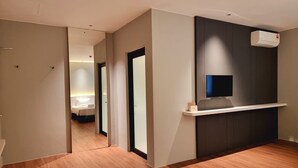 A hotel hallway with wooden flooring, a reception desk, and a TV mounted on the wall. - ROXY HOTEL MALIHAH (Kuching)