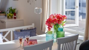 A dining table with a vase of flowers, two glasses, and a menu. - Nordseezauber - North Sea magic - Holiday apartment near the beach with sea view in (Wenningstedt-Braderup (Sylt))