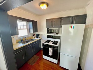 Een microgolfoven, een oven, een kookplaat, kookgerei, borden en bestek