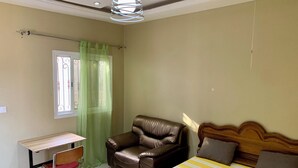 Ein Schlafzimmer mit einem Bett, einem Schreibtisch und einem Ledersessel.