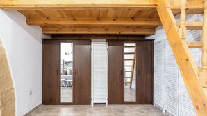 A room with a wooden ceiling, a sliding door, and a ladder. - Amalia's Traditional Home In Paradisi (Paradeisi)