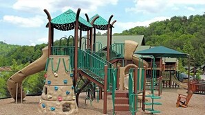 Une aire de jeux avec des structures d’escalade, des toboggans et un espace abrité.