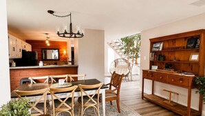 A cozy interior with a dining area, wooden furniture, a bookshelf, and a staircase leading to an outdoor area. - Private Retreat w/ Animals. Outdoor Fire pit/ BBQ (Cedar Creek)