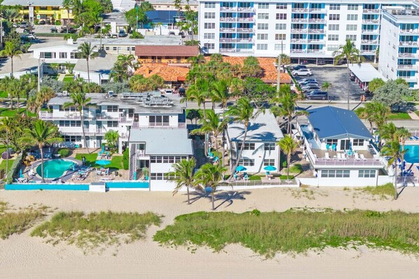 A beachfront property with multiple buildings, a swimming pool, and palm trees. - Pool + Beachfront Studio! (Lauderdale-by-the-Sea)
