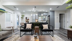 A modern living room with a wooden coffee table, two black chairs, a grey sofa, and a patterned rug. - Away in the Woods~ Pinnacle, Wi-Fi (Little Rock)