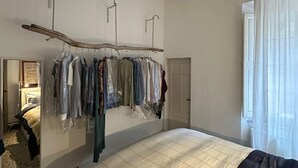 Ein Schlafzimmer mit einem Bett, einem Holzmantelständer und einem Kleiderschrank.