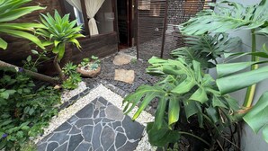 A courtyard with a stone pathway, potted plants, and a wooden fence. - Beautiful country (Rionegro)