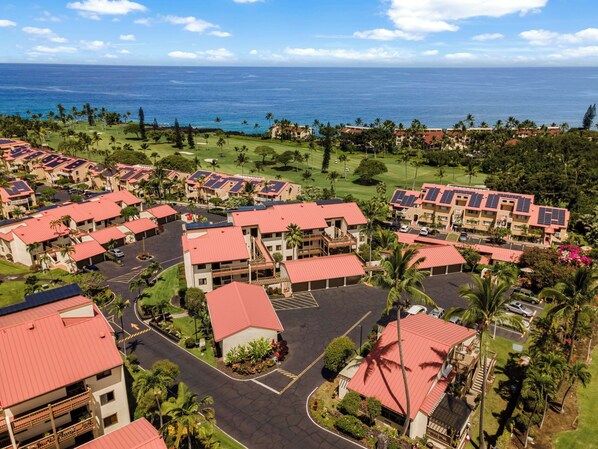 Un resort con varias edificaciones, un campo de golf y vista al océano.