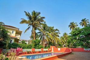 A residential area with a swimming pool, palm trees, and houses. - Ocean Dream Luxury Villa (Arpora)
