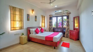 A bedroom with a bed, a nightstand, a dresser, a ceiling fan, and a window with curtains. - Ocean Dream Luxury Villa (Arpora)