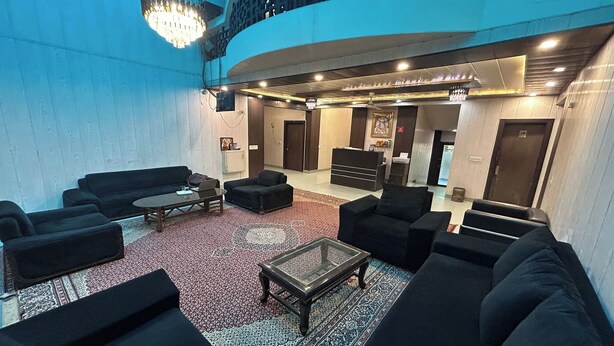 A spacious lobby with black sofas, a coffee table, and a patterned rug. - Hotel B K House (Noida)