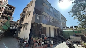 A multi-story residential building with a modern design, featuring balconies and a staircase leading to the entrance. - Hotel B K House (Noida)