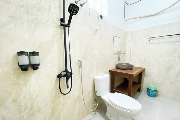 A bathroom with a toilet, a shower, and a sink.
