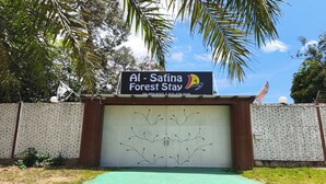 Schild für Al - Safina Forest Stay mit Telefonnummer und Logo.