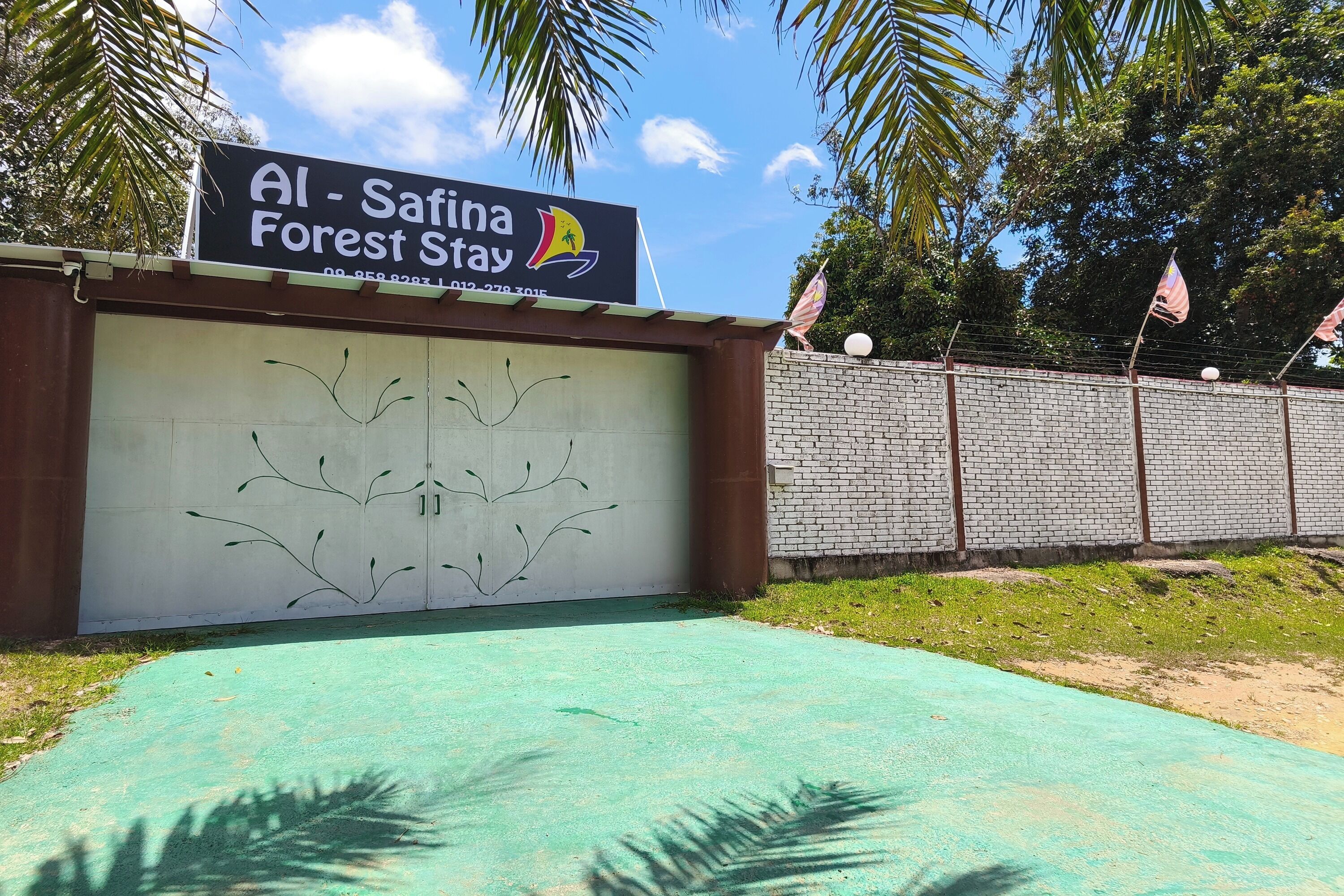 A sign for Al - Satina Forest Stay with a contact number and a tree design on the garage door.