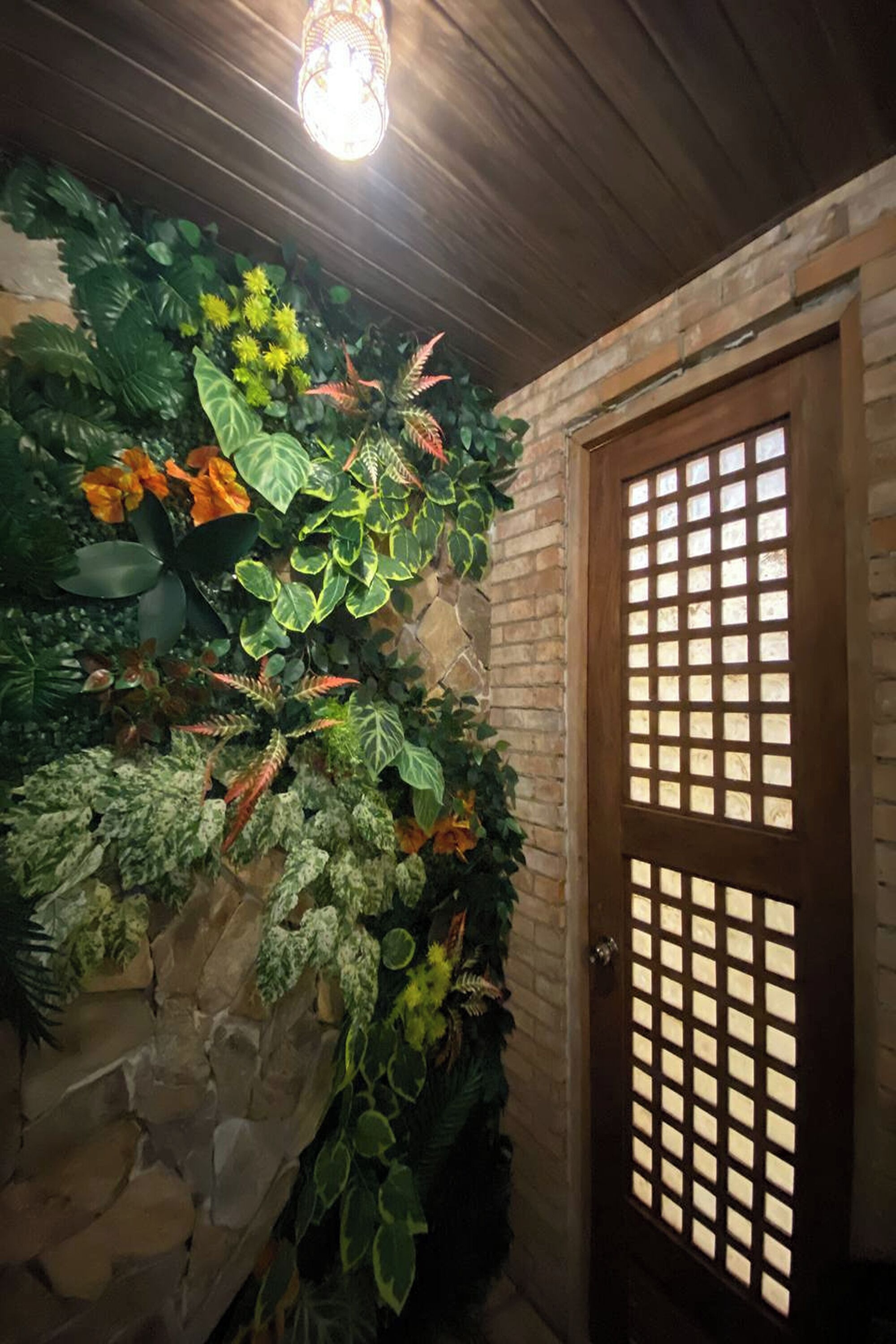 Una habitación con pared de piedra y puerta de madera con diseño de cuadrícula.