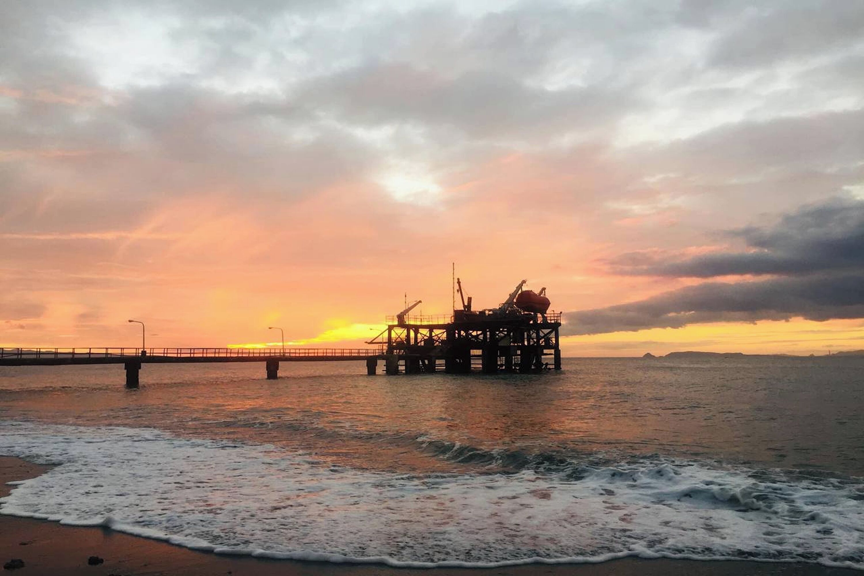 A pier extending into the water with a platform structure, likely for industrial or maritime purposes.