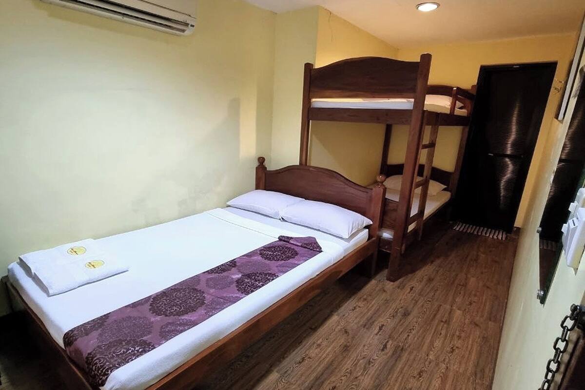 Une chambre avec un lit simple et un lit superposé.