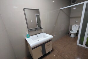 A bathroom with a white sink, mirror, and toilet. - La Belladoza near NAIA T1 Airport (Paranaque)
