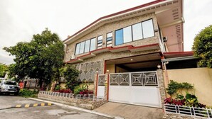 A two-story house with a garage, a white gate, and a stone facade. - La Belladoza near NAIA T1 Airport (Paranaque)