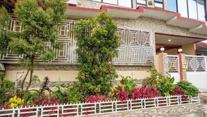 A building with a stone facade, a white fence, and various plants. - La Belladoza near NAIA T1 Airport (Paranaque)