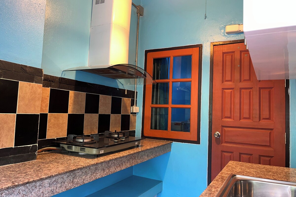 A kitchen with a gas stove, a built-in oven, and a blue tiled backsplash.