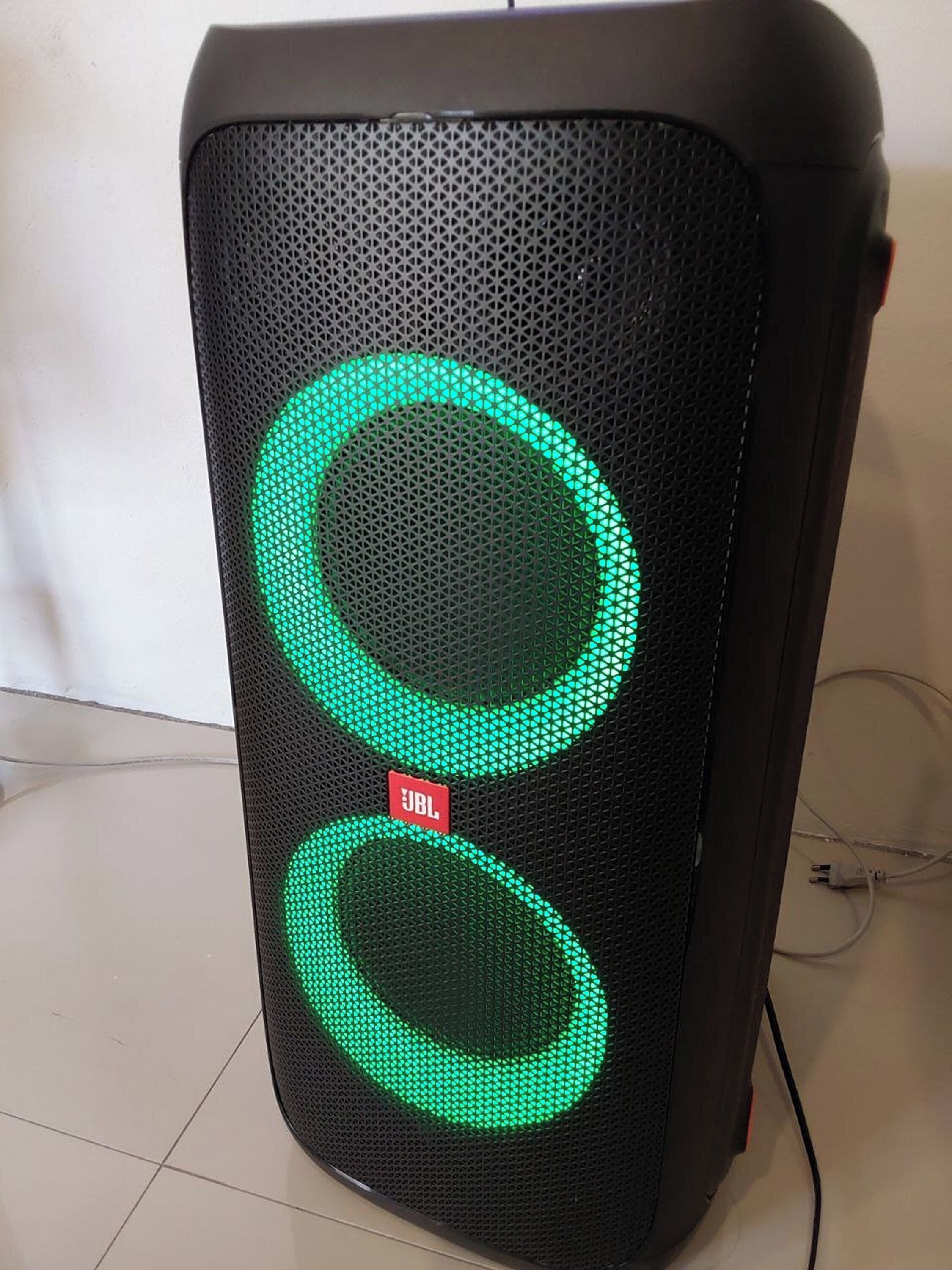 Musta kaiutin, jossa on kaksi vihreää, valaistua rengasta ja JBL-logo.