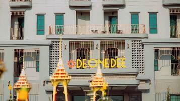 A building with a sign reading "DE O N E D E" and a decorative entrance with a fountain.