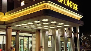 A hotel with a prominent 'DE ONE DEF' sign, large windows, and a well-lit entrance area. - Hotel De One Dee (Chiang Kham)