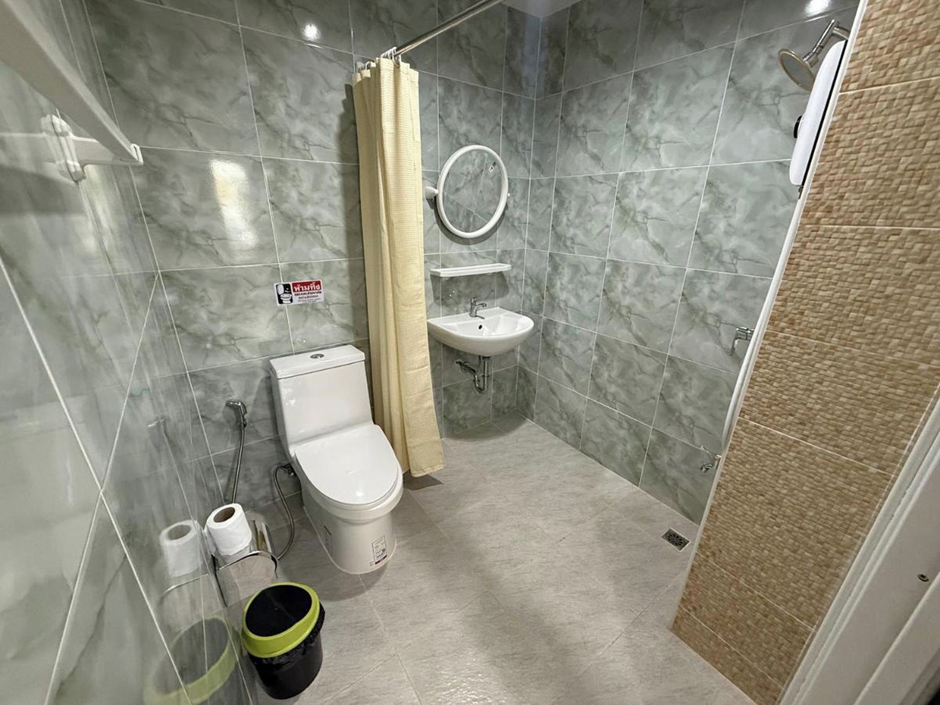 A bathroom with a toilet, sink, and shower.