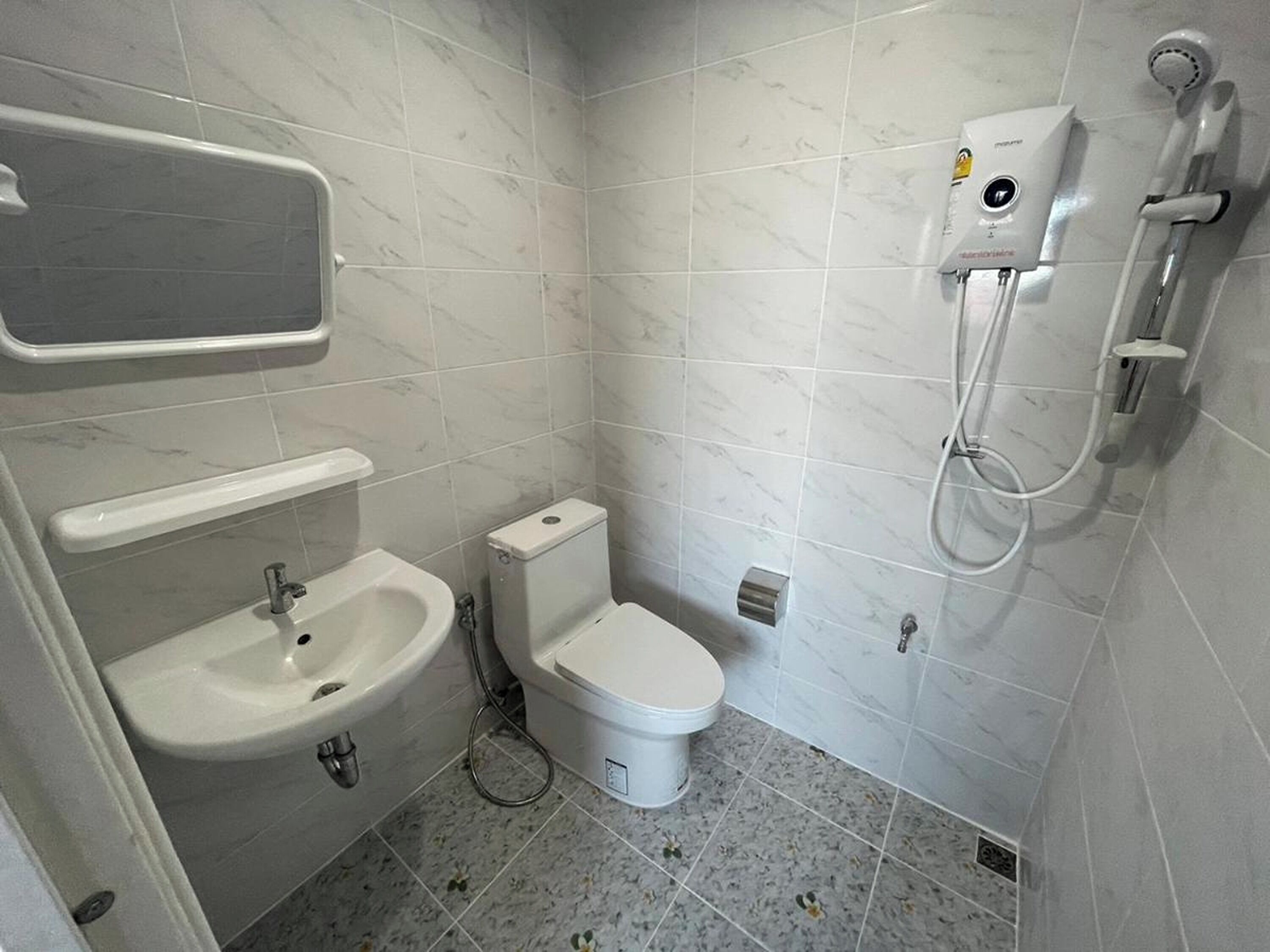 Un baño pequeño con inodoro, lavamanos y ducha.