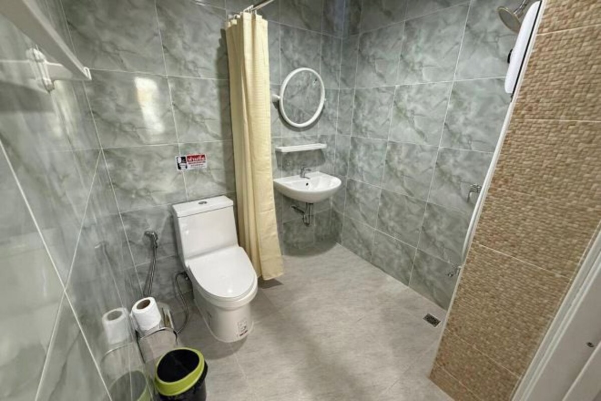 A bathroom with a toilet, sink, and shower.